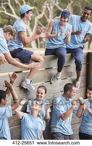 Team clapping and celebrating at wall on boot camp obstacle course View Large Photo Image Stock Image - Team clapping and celebrating at wall on boot camp obstacle course. Fotosearch