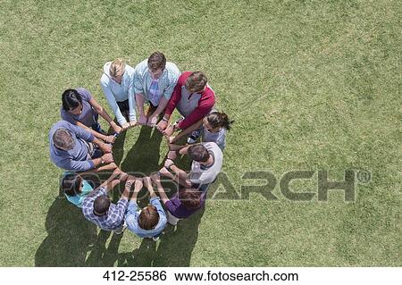 Team connected in circle around plastic hoop in field View Large Photo Image Stock Photograph - Team connected in circle around plastic hoop in field. Fotosearch