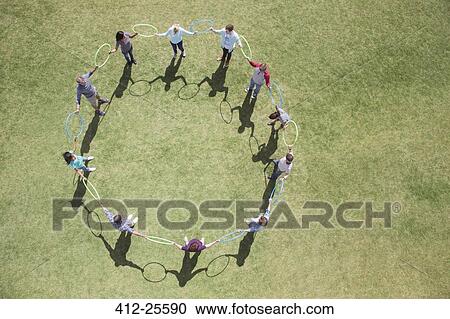 Team connected in circle by plastic hoops in sunny field View Large Photo Image Stock Image - Team connected in circle by plastic hoops in sunny field. Fotosearch
