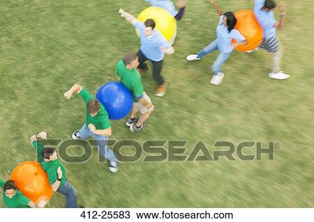 Teammates performing fitness ball team building activity View Large Photo Image Stock Image - Teammates performing fitness ball team building activity. Fotosearch