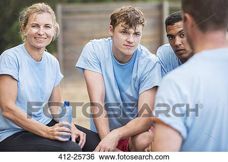 Tired team resting and drinking water at boot camp View Large Photo Image Stock Photograph - Tired team resting and drinking water at boot camp. Fotosearch