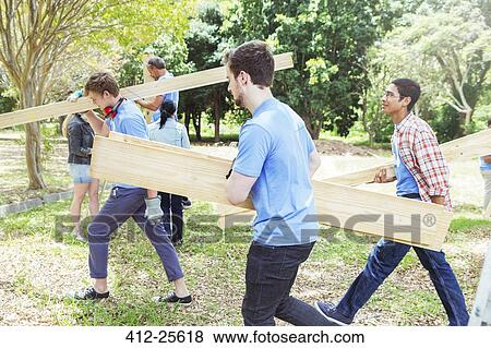 Volunteers carrying wood planks View Large Photo Image Stock Photo - Volunteers carrying wood planks. Fotosearch