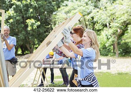 Volunteers lifting construction frame at construction site View Large Photo Image Stock Image - Volunteers lifting construction frame at construction site. Fotosearch