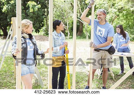 Volunteers talking at construction site View Large Photo Image Stock Image - Volunteers talking at construction site. Fotosearch