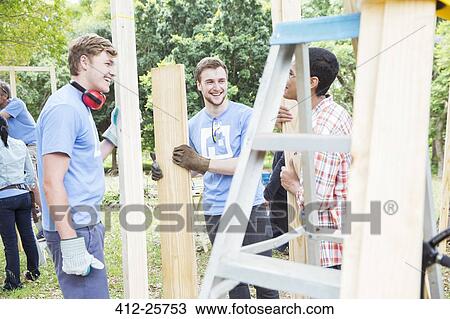 Volunteers talking at construction site View Large Photo Image Stock Image - Volunteers talking at construction site. Fotosearch