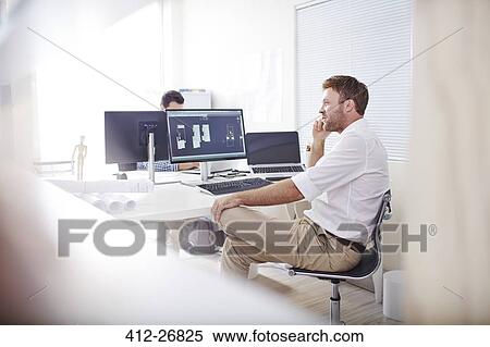 Architect talking on cell phone at computer in office View Large Photo Image Stock Photography - Architect talking on cell phone at computer in office. Fotosearch