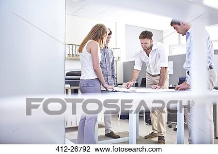 Architects reviewing blueprints in meeting View Large Photo Image Stock Image - Architects reviewing blueprints in meeting. Fotosearch