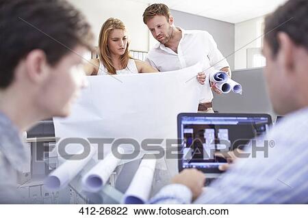 Architects reviewing blueprints in office View Large Photo Image Stock Image - Architects reviewing blueprints in office. Fotosearch