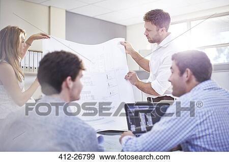 Architects reviewing blueprints in meeting in office View Large Photo Image Stock Photo - Architects reviewing blueprints in meeting in office. Fotosearch