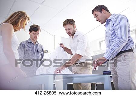 Architects reviewing blueprints in meeting in office View Large Photo Image Stock Photography - Architects reviewing blueprints in meeting in office. Fotosearch