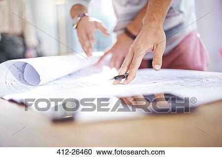 Architects reviewing blueprints View Large Photo Image Stock Image - Architects reviewing blueprints. Fotosearch