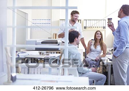 Stock Photograph - Architects talking and drinking coffee in office. Fotosearch