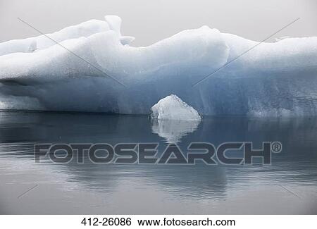 Stock Photograph - "Blue iceberg formation in calm water, Jokulsarlon, Iceland". Fotosearch