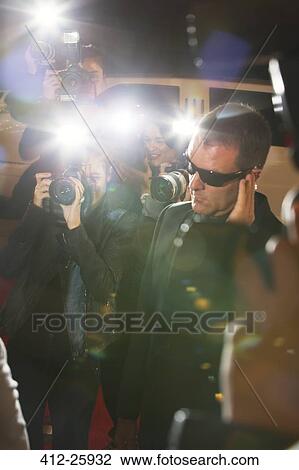 Bodyguard surrounded by paparazzi photographers at event View Large Photo Image Stock Image - Bodyguard surrounded by paparazzi photographers at event. Fotosearch