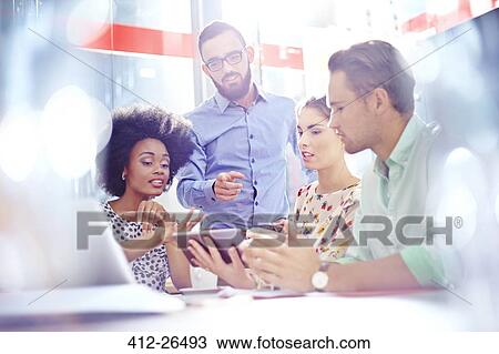 Stock Image - Business people meeting around digital tablet. Fotosearch