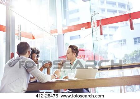 Stock Photograph - Business people meeting in sunny cafe. Fotosearch