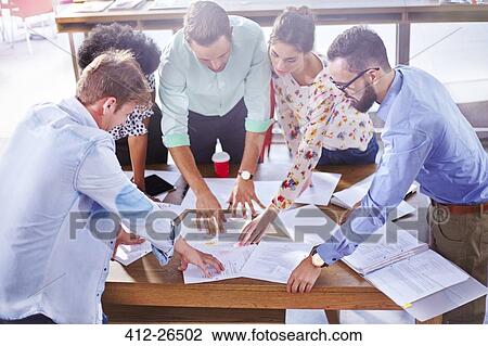 Business people reviewing paperwork and brainstorming in meeting View Large Photo Image Stock Image - Business people reviewing paperwork and brainstorming in meeting. Fotosearch