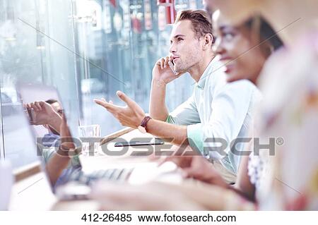 Businessman talking on cell phone in cafe View Large Photo Image Stock Photography - Businessman talking on cell phone in cafe. Fotosearch