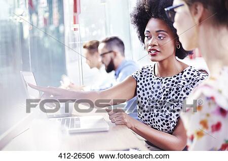 Stock Photograph - Businesswomen using laptop in cafe. Fotosearch