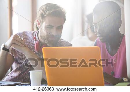 Casual business people working at laptop View Large Photo Image Stock Image - Casual business people working at laptop. Fotosearch