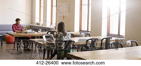 Casual business people working at tables in open office View Large Photo Image Stock Image - Casual business people working at tables in open office. Fotosearch