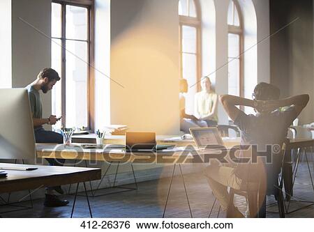 Stock Photograph - Casual business people working in open office. Fotosearch