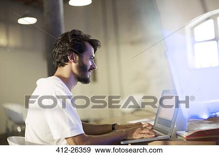 Casual businessman working at laptop in conference room View Large Photo Image Stock Photo - Casual businessman working at laptop in conference room. Fotosearch