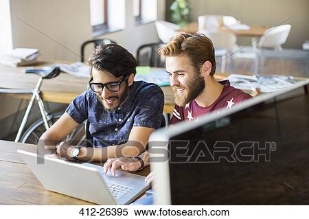 Casual businessmen working at laptop in office View Large Photo Image Stock Photography - Casual businessmen working at laptop in office. Fotosearch