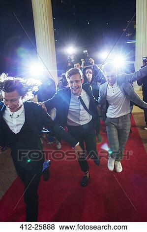 Stock Photo - Celebrities arriving and running from paparazzi photographers at red carpet event. Fotosearch