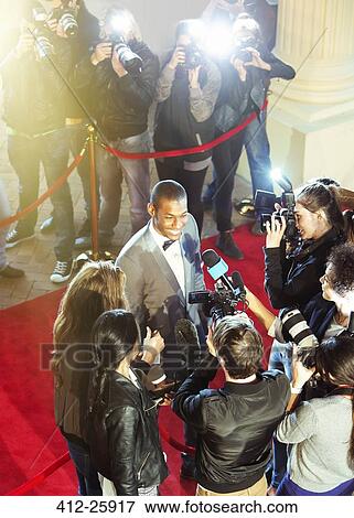 Celebrity being interviewed and photographed by paparazzi photographer at red carpet event View Large Photo Image Stock Photo - Celebrity being interviewed and photographed by paparazzi photographer at red carpet event. Fotosearch