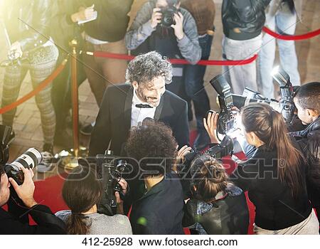 Stock Photo - Celebrity being interviewed and photographed by paparazzi photographers at red carpet event. Fotosearch
