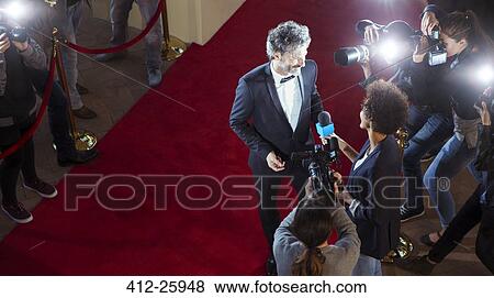 Celebrity being interviewed and photographed by paparazzi photographers at red carpet event View Large Photo Image Stock Photo - Celebrity being interviewed and photographed by paparazzi photographers at red carpet event. Fotosearch