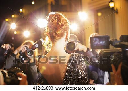 Stock Image - Celebrity being photographed by paparazzi photographers at event. Fotosearch