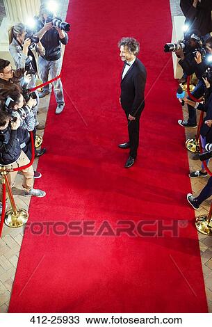 Stock Image - Celebrity being photographed by paparazzi photographers at red carpet event. Fotosearch