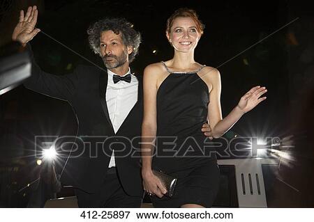 Celebrity couple arriving and waving to paparazzi at event View Large Photo Image Stock Photo - Celebrity couple arriving and waving to paparazzi at event. Fotosearch