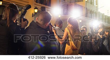 Stock Photograph - Celebrity couple being photographed at red carpet event. Fotosearch