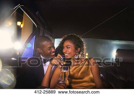Celebrity couple drinking champagne inside limousine outside event View Large Photo Image Stock Photo - Celebrity couple drinking champagne inside limousine outside event. Fotosearch