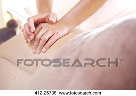 Stock Photo - Close up of masseuse massaging woman’s back. Fotosearch