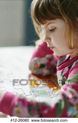 Close up of serious girl assembling jigsaw puzzle View Large Photo Image Stock Image - Close up of serious girl assembling jigsaw puzzle. Fotosearch