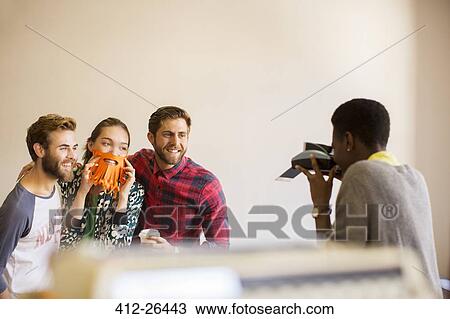Creative business people playfully posing for coworker with instant camera View Large Photo Image Stock Image - Creative business people playfully posing for coworker with instant camera. Fotosearch