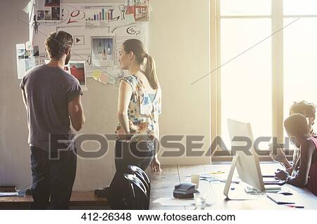 Creative business people reviewing proofs and notes on office wall View Large Photo Image Stock Photo - Creative business people reviewing proofs and notes on office wall. Fotosearch