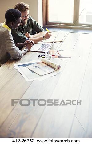 Creative business people working at laptop in office View Large Photo Image Stock Image - Creative business people working at laptop in office. Fotosearch