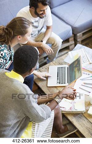 Stock Image - Creative business people working at laptop in office. Fotosearch