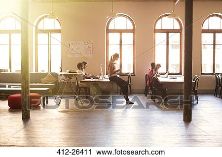 Stock Image - Creative business people working in sunny open office. Fotosearch