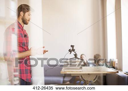Creative businessman recording video with cell phone in office View Large Photo Image Stock Photography - Creative businessman recording video with cell phone in office. Fotosearch