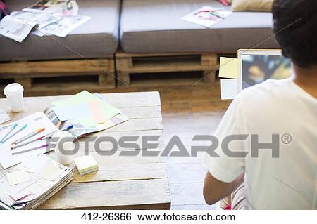Creative businessman working at laptop near color proofs in office View Large Photo Image Stock Photograph - Creative businessman working at laptop near color proofs in office. Fotosearch