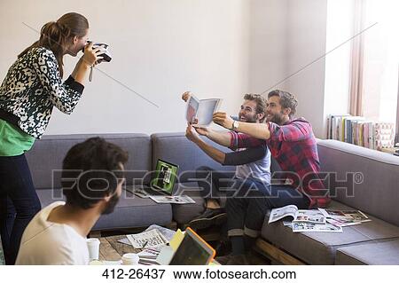 Creative businessmen with proofs posing for coworker with instant camera View Large Photo Image Stock Photo - Creative businessmen with proofs posing for coworker with instant camera. Fotosearch
