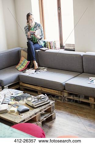 Creative businesswoman reading book at window in office View Large Photo Image Stock Photo - Creative businesswoman reading book at window in office. Fotosearch