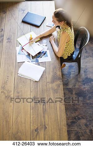 Creative businesswoman writing in notebook at table in office View Large Photo Image Stock Image - Creative businesswoman writing in notebook at table in office. Fotosearch