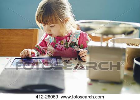 Curious girl using digital tablet View Large Photo Image Stock Photo - Curious girl using digital tablet. Fotosearch